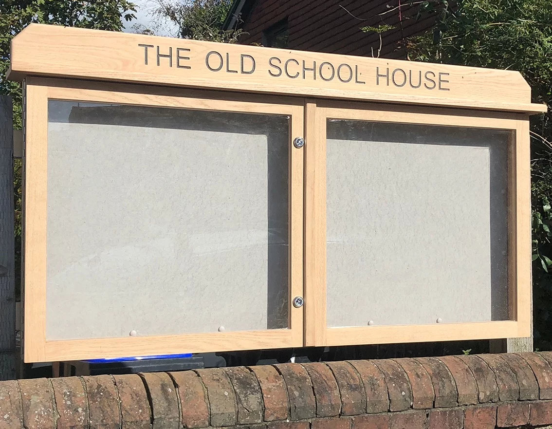 Oak notice board with two doors and engraved header