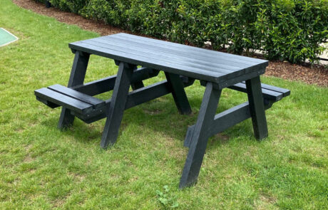 Black recycled plastic picnic table set in grass with room for a wheelchair