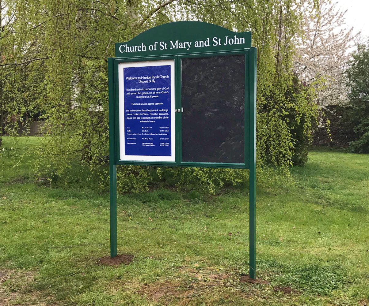 Two door notice board with header set in grass